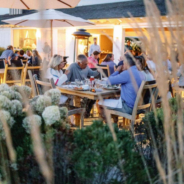 group of four people dining outside at wychmere beach club.