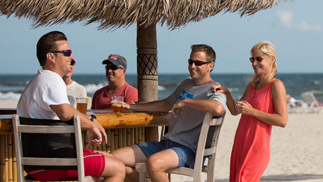 Customers on the beach enjoying the tiki bar