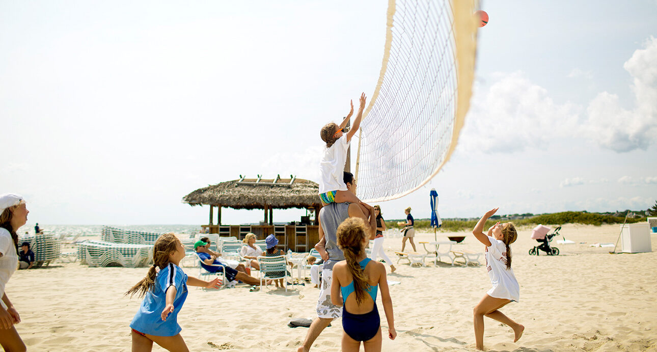 Kids playing beach volleyball.