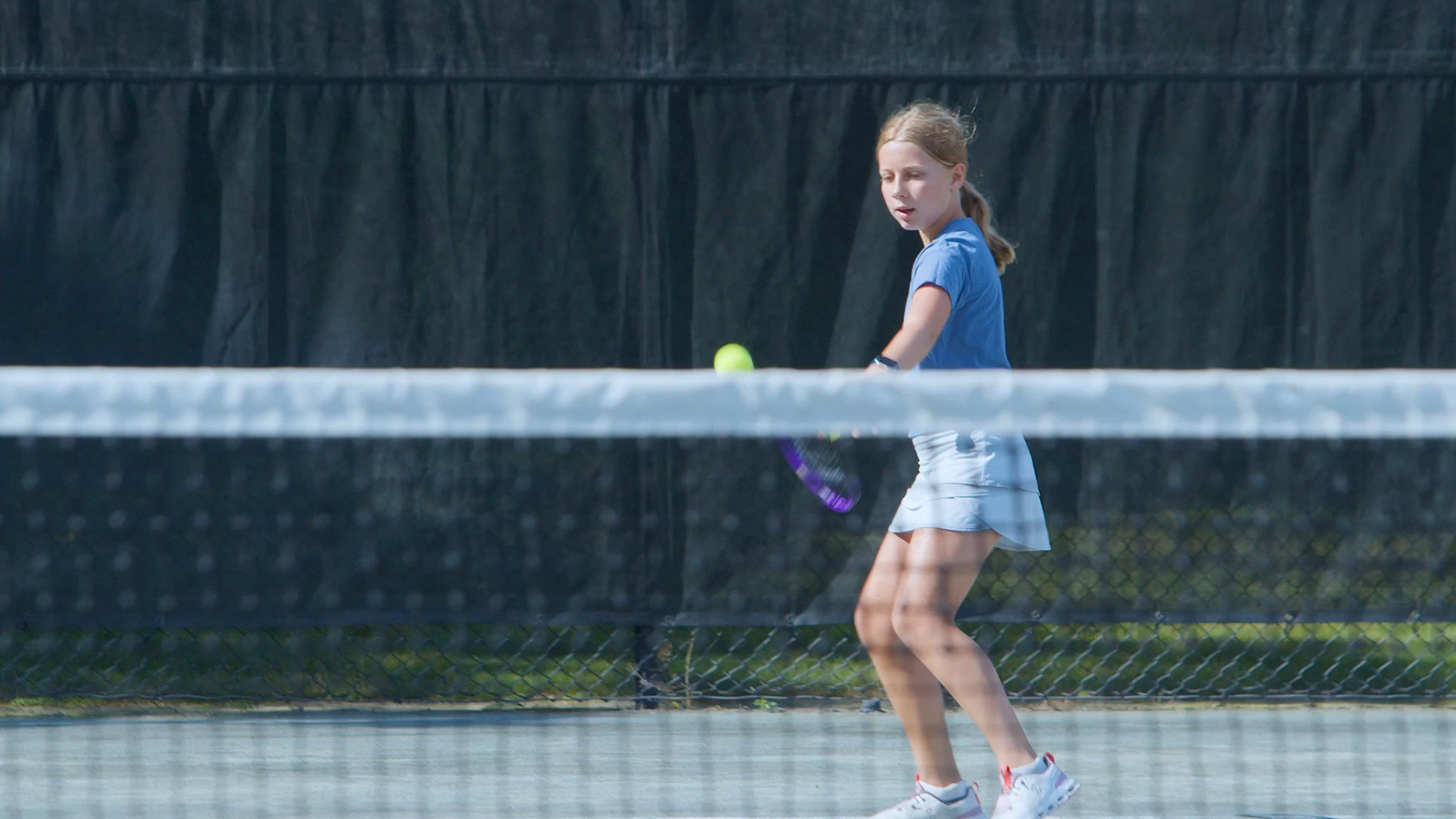 girl returning tennis serve.